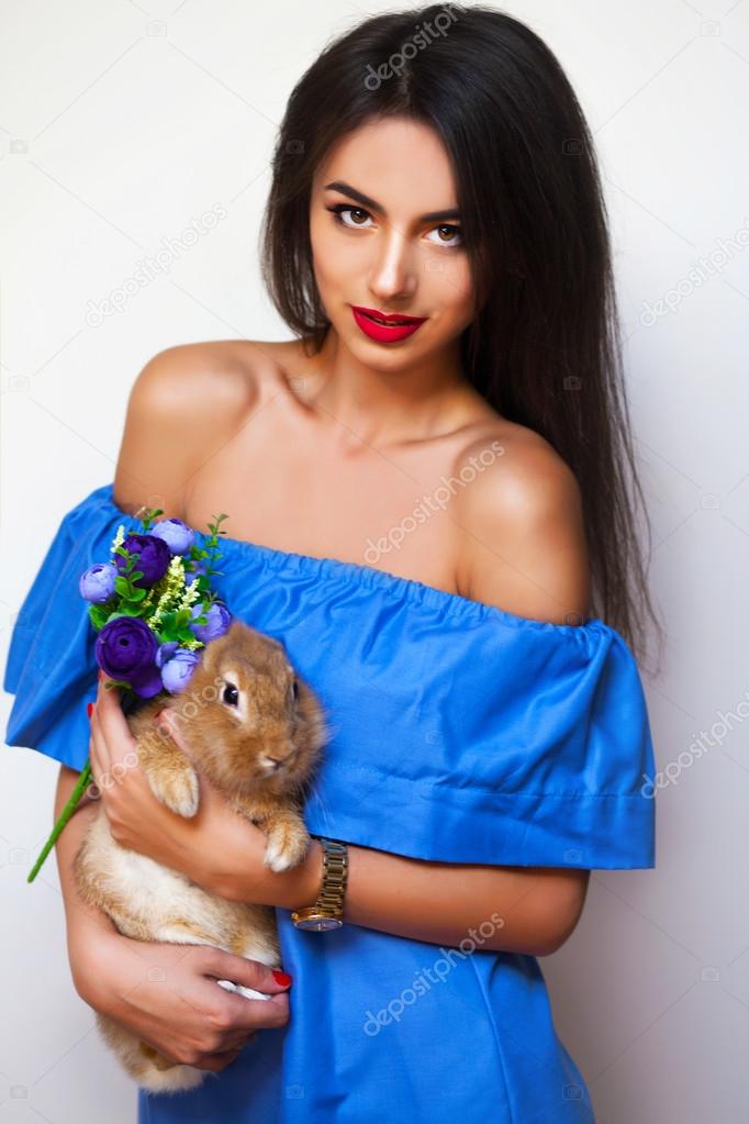 Attractive woman with rabbit and flowers