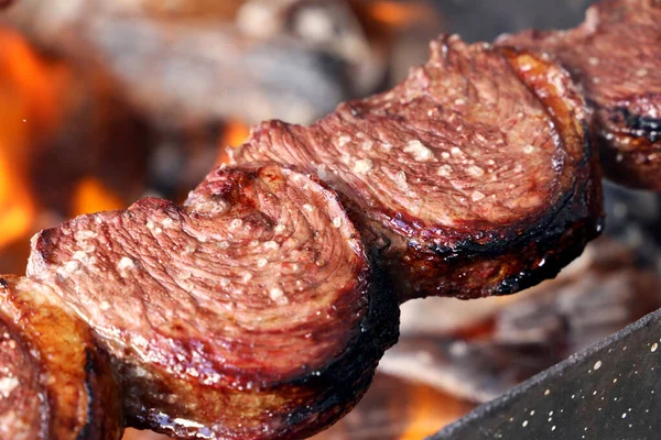 Picanha. Brezilya barbeküsünde geleneksel biftek ve yangın arka planı.