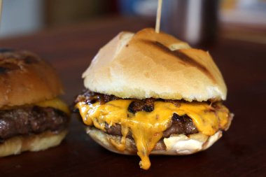 Peynirli burger ve ızgarada pişirilmiş ekmek. Yan görüş. Kapatın. Ahşap arka planda.