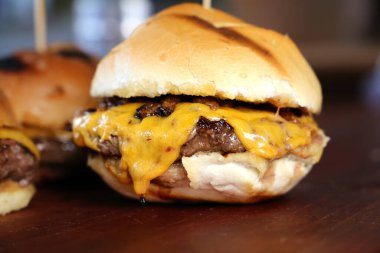 Peynirli burger ve ızgarada pişirilmiş ekmek. Yan görüş. Kapatın. Ahşap arka planda.