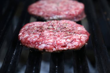 Brezilya barbeküsünde ızgarada çiğ hamburger..
