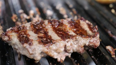 Güzel sulu Picanha, ızgaranın üstünde ızgara izleri ve arka planda parlayan kömürle yakın çekim yap..