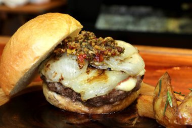 Soğanlı hamburger ve Chimichurri. Kırsal ahşap bir arka planda.