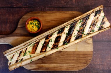 Ahşap bir tahtanın üzerinde, yanında bıçak ve hardal sosuyla barbekü işaretleri olan güzel kalpler..