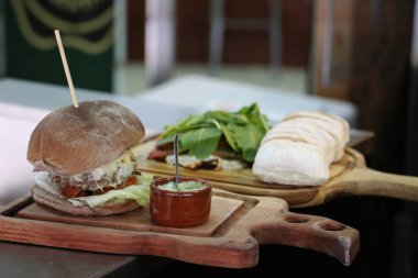 Peynirli burger, domates ve ızgarada yapılan ekmek. Yan görüş. Kapat..