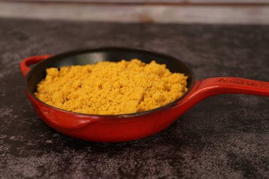 Farofa ile kırmızı demir tencere. Geleneksel Brezilya yemekleri. Karanlık bir arka planda.