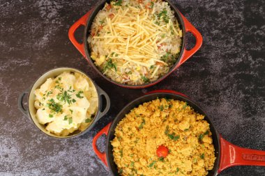 Farofa ile kırmızı demir tencere. Geleneksel Brezilya yemekleri. Karanlık bir arka planda.