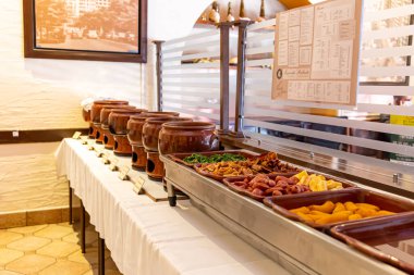 Brezilya restoranının büfesi. Fayjoada, sosis ve lahana servisi. Brezilya yemekleri..