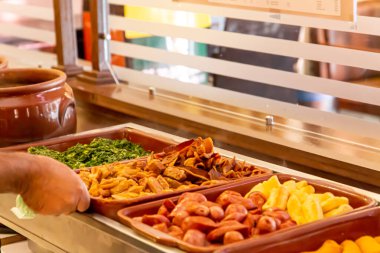 Brezilya restoranının büfesi. Fayjoada, sosis ve lahana servisi. Brezilya yemekleri..