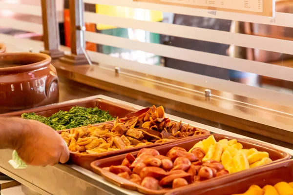 Brezilya restoranının büfesi. Fayjoada, sosis ve lahana servisi. Brezilya yemekleri..