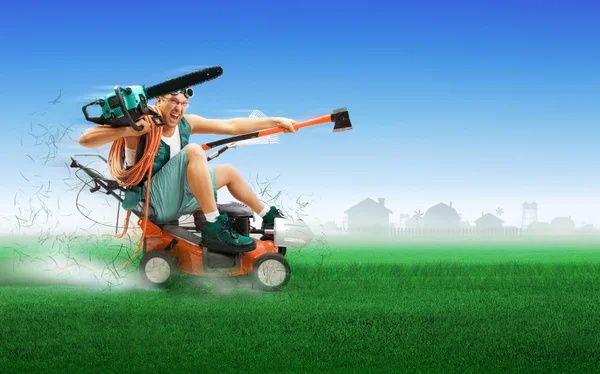 Gek workman bedekt met instrumenten grasmaaier rijden over groen gras — Stockfoto