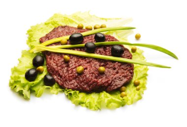 Çiğ et soğan, zeytin ve salata ile dekore edilmiş beyaz arka plan üzerinde