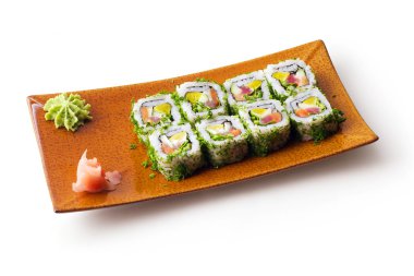 Beyaz arka plan üzerinde kahverengi kare tabakta ton balığı, somon, peynir ve salatalık ile Rulo