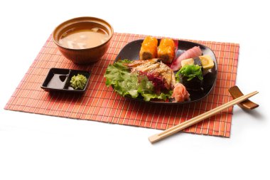 Miso çorbası, sushi, maguro, salata ve yemek çubukları üzerinde beyaz arka plan üzerinde paspas ile Asya iş yemeği