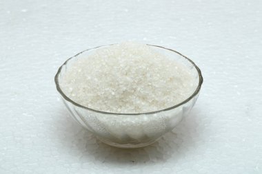 Beyaz arka planda cam kasede beyaz şeker