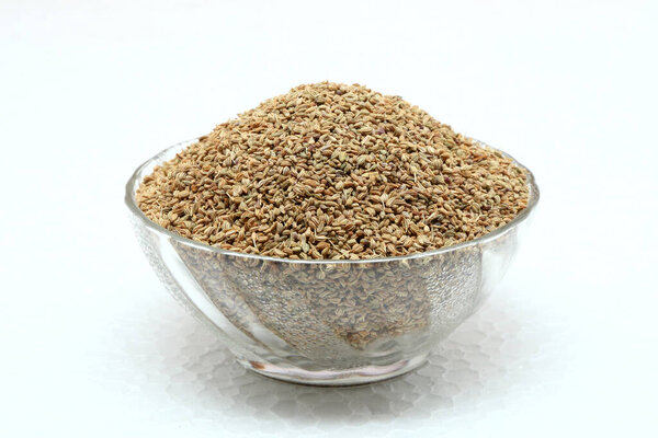 Carom seeds in glass bowl on white background