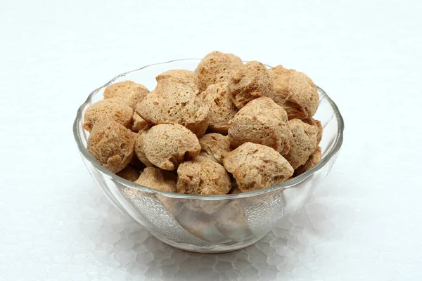 Soya beyaz arka planda cam bir kasede parçalanmış.