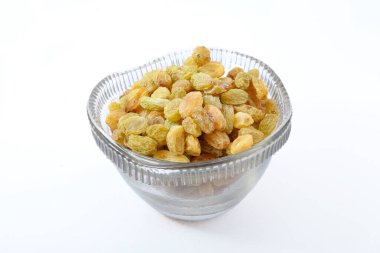 Beyaz arka planda cam kasede kuru üzümler