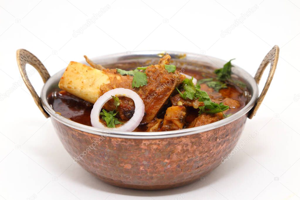 Indian meat dish or mutton curry in a copper brass bowl.