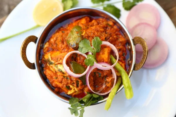 INDIAN STYLE COTTAGE CHEESE VEGETARIAN CURRY DISH. Kadai Paneer - Traditional Indian or Punjabi food. Garnished with onion and chili slices.