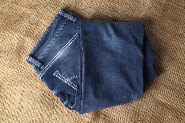 Old Blue Jeans Fashion Design Auf Braunem Hanfsack Textur Hintergrund — Stockfoto