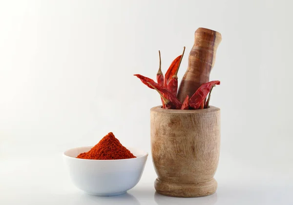 Kırmızı biber ve beyaz arka planda kırmızı biber tozu..