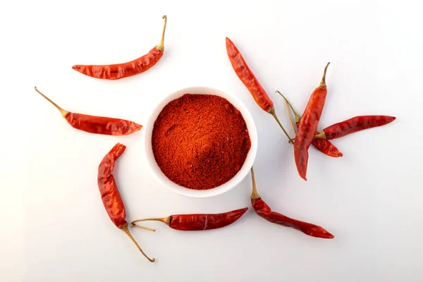 Red chillies with red chilly powder on white background.