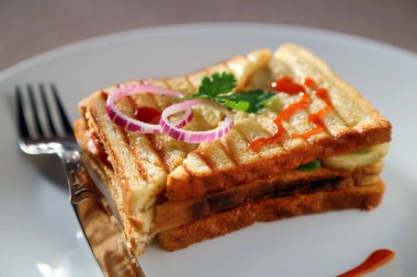 Beyaz seramik tabakta bir sandviç.