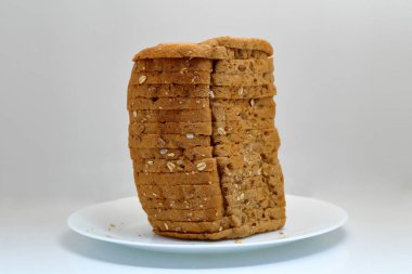 Beyaz zemin üzerinde seramik bir tabakta taze multi tahıllı ekmek