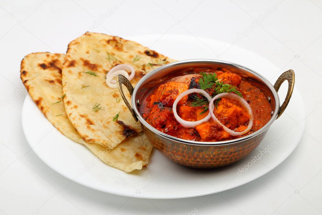 Indian Food or Indian Curry in a copper brass serving bowl with bread or roti.