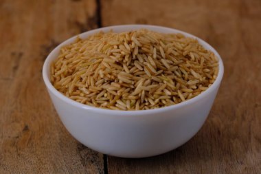 Kase içinde çiğ kahverengi pirinç.