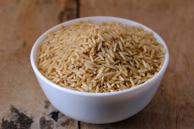 Kase içinde çiğ kahverengi pirinç.