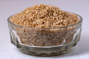 Kase içinde çiğ kahverengi pirinç.