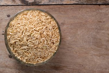 Kase içinde çiğ kahverengi pirinç.