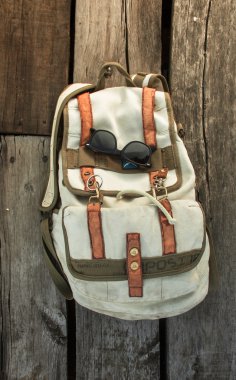 sırt çantası vintage gözlük ile ahşap bir arka plan üzerinde seyahat