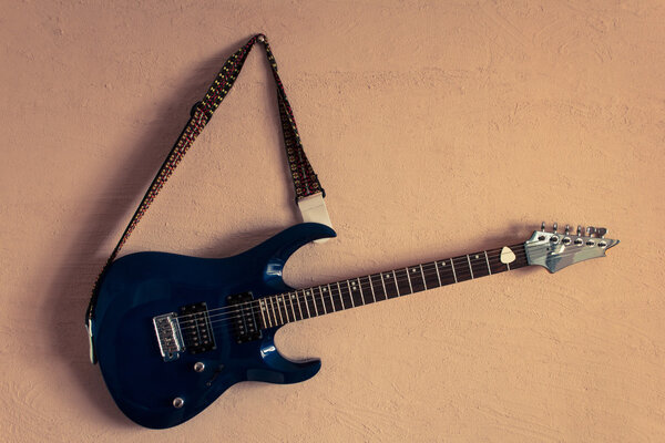 electric guitar on a background of vintage beige wall