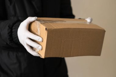 Kurye kızın elinde koruyucu eldivenler var. salgın