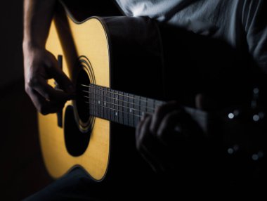 Gitar çalma pratiği. Gitar çalan yakışıklı genç adam.