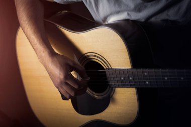 Gitar çalma pratiği. Gitar çalan yakışıklı genç adam.