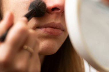 Kız kendine makyaj yapıyor. Yakın plan. makyaj aynası.