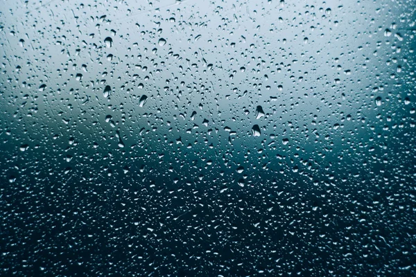 Water droplets on glass. close-up. macro plan. blue background. — Stock Photo, Image