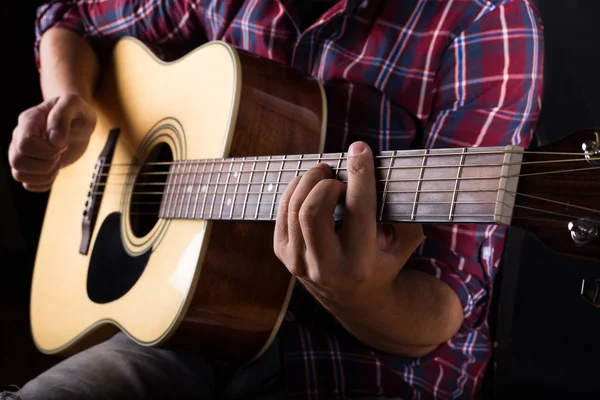 Genç adam stüdyoda bir akustik gitar çalmak — Stok fotoğraf