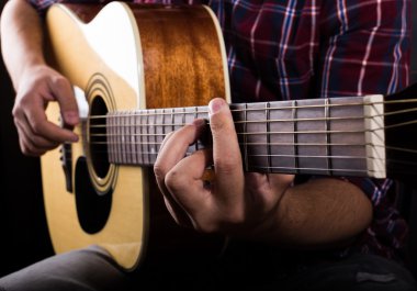 Stüdyoda bir akustik gitar çalmak genç adam
