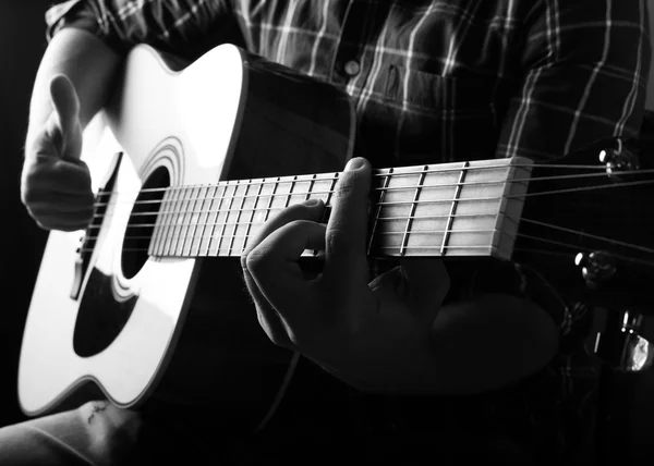 El joven tocando una guitarra acústica en el estudio . — Foto de Stock