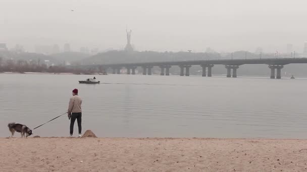가을 해변에 그의 강아지와 함께 산책 하는 남자 — 비디오