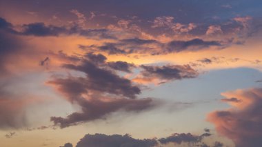 Gün batımında dramatik bulutlarla dinamik gökyüzünün panoramik görüntüsü.