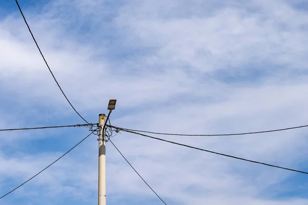 Electricity pole with wires on rural field