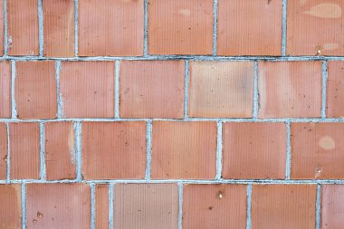 Delinmiş yapıya sahip kırmızı tuğlalardan (kil bloklar) oluşan duvar 