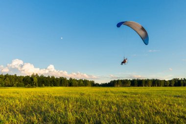 Güzel bir yaz gününde yeşil çayır üzerinde güçlü bir yamaç paraşütü