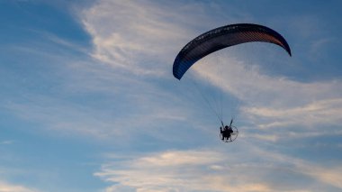 Mavi gökyüzüne karşı güçlü paraglider silueti